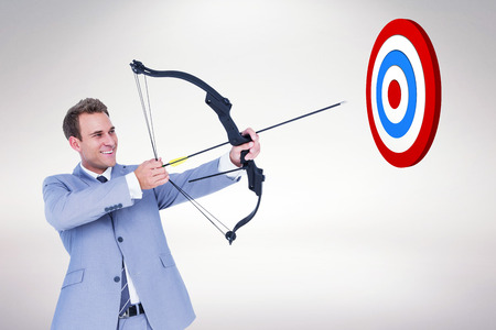 Businessman shooting arrow against white background with vignetteの写真素材