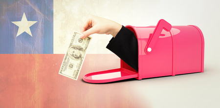 Businesswomans hand holding hundred dollar bill against chile flag in grunge effect
