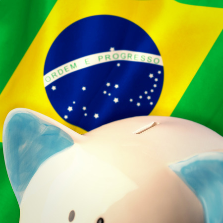 Piggy bank against digitally generated brazilian national flagの写真素材