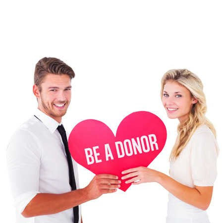 Attractive young couple holding red heart against be a donorの写真素材