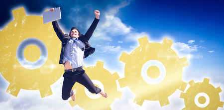 Cheering businessman against bright blue sky with cloudsの写真素材