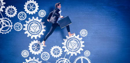 Leaping businessman against blue chalkboardの写真素材