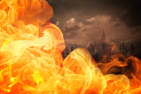 Fire against stormy sky over city