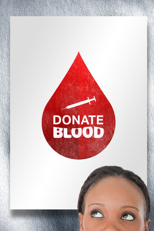 Close up of woman looking upwards diagonally on white background against white cardの写真素材