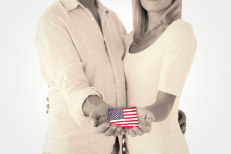 Happy couple holding their hands out against usa national flagの写真素材