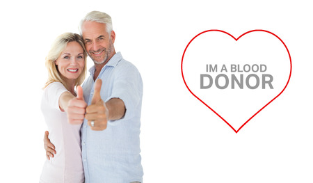 Smiling couple showing thumbs up together against blood donationの写真素材