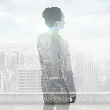 Unsmiling asian businesswoman against cityscapeの写真素材