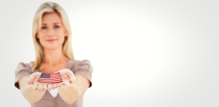 Happy blonde holding hands out against usa national flag