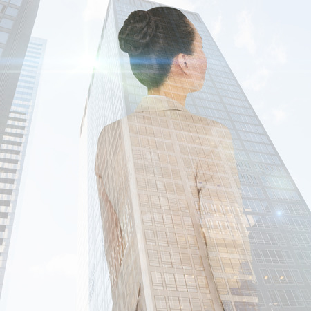 Asian businesswoman against skyscraperの写真素材