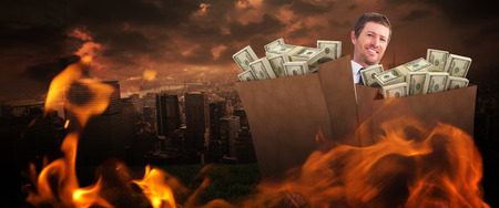 Businessman carrying bag of dollars against stormy sky over cityの写真素材