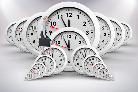 Businesswoman climbing with briefcase against grey background