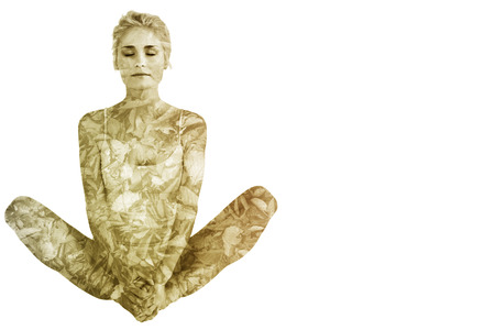 Toned woman doing the butterfly stretch against detail shot of dry leavesの写真素材