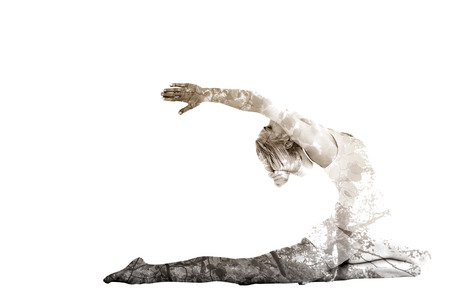 Toned young woman stretching hands backwards against tranquil autumn scene in forestの写真素材