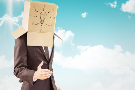 Anonymous businessman offering his hand against blue skyの写真素材