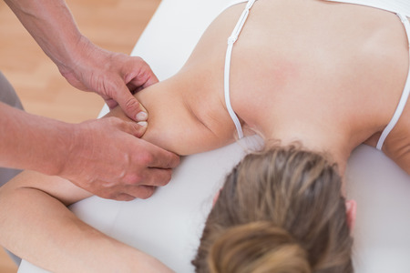 Physiotherapist doing arm massage to his patient in medical officeの写真素材