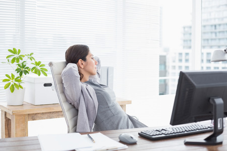 Businesswoman relaxing in a swivel chair in her officeの写真素材