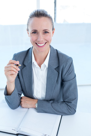 Smiling businesswoman looking at camera in the officeの写真素材