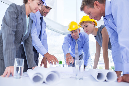 Team of business people looking at construction plan in the office
