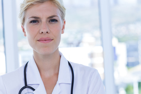 Confident doctor looking at camera in medical officeの写真素材