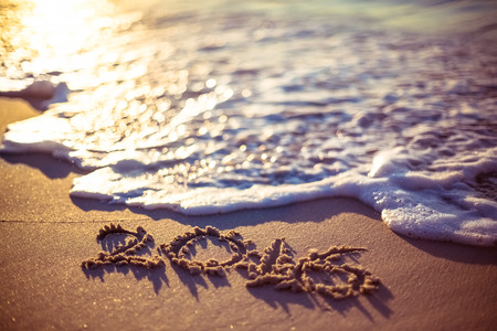 love written on the beach at the sunset