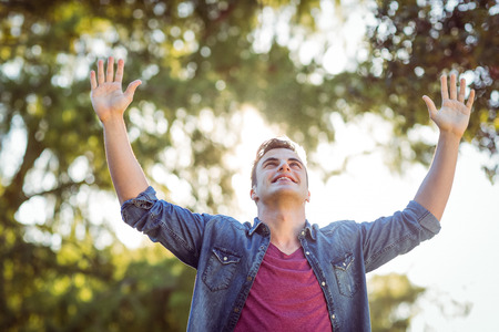Handsome arms raised hipster on a sunny day