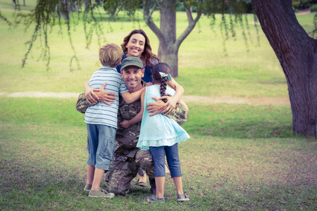 Handsome soldier reunited with family on a sunny dayの写真素材