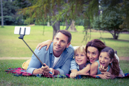 Happy family in the park taking selfie on a sunny dayの写真素材