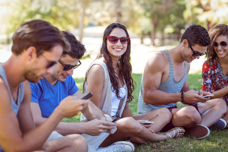 Pretty hipster smiling in the park on a sunny day