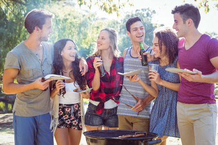 Happy friends in the park having barbecue on a sunny dayの写真素材