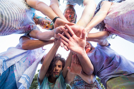 Happy friends covered in powder paint on a sunny dayの写真素材