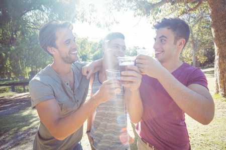 Happy friends in the park having beers on a sunny dayの写真素材