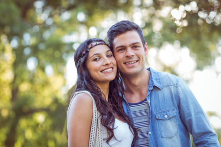 Cute couple smiling in the park on a sunny dayの写真素材