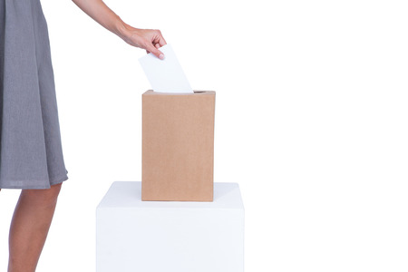 Businesswoman putting ballot in vote box  on white backgroundの写真素材