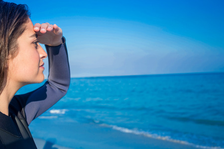 Woman in wetsuit on a sunny day at the beachの写真素材
