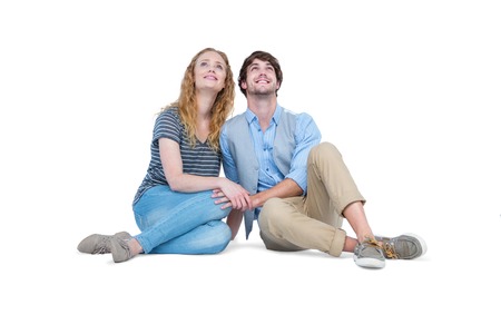 Happy couple sitting on the floor on white backgroundの写真素材