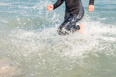 Swimmer running in the ocean on a sunny dayの写真素材