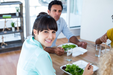 Young businesswoman having lunch with her colleaguesの写真素材