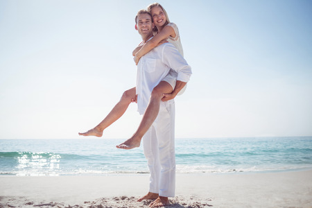 Happy couple having fun on the beach on a sunny dayの写真素材