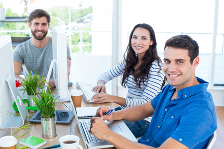 Creative business people using laptop in meeting at office