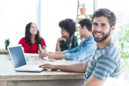 Casual smiling businessman looking at the camera in the office