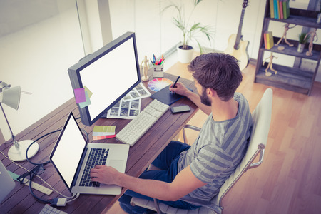 Casual young businessman using computers in officeの写真素材