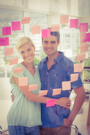 Portrait of business partners posing in front of pink heart posts itの写真素材