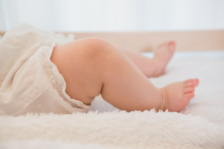 Beautiful legs of baby at home in bedroomの写真素材