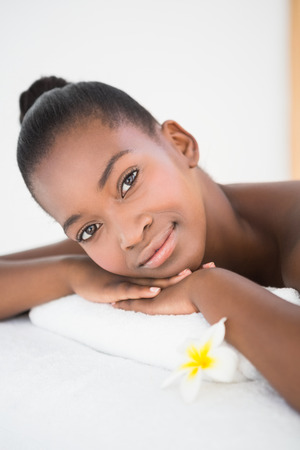 Pretty woman lying on massage table smiling at the camera at the health spaの写真素材