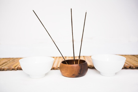 Incense burning and perfumed candles nearby a bamboo matの写真素材