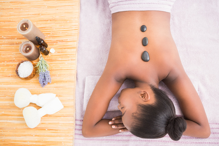 Pretty woman enjoying a hot stone massage at the health spaの写真素材