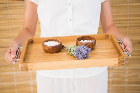 Therapist holding tray of beauty treatments at the spaの写真素材