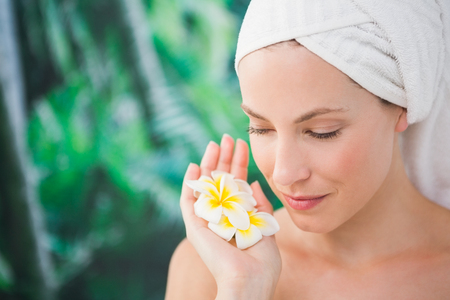 Close up of a beautiful young woman holding flower over white backgroundの写真素材