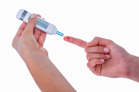 Diabetic woman using blood glucose monitor on white background