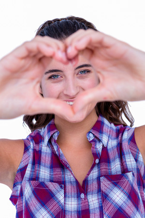 Happy pretty woman making heart shape with hands on white backgroundの写真素材